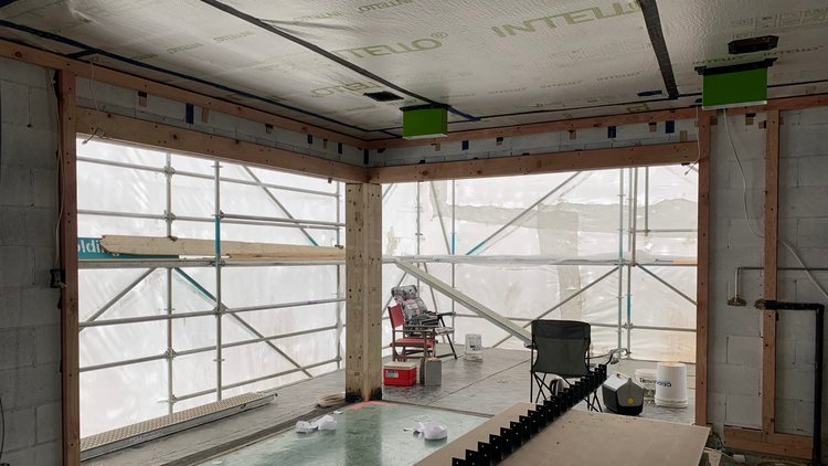 Piha Passive House - Connecting pro clima sealing tapes to the window frames and concrete walls installed with INTELLO<sup>®</sup> PLUS